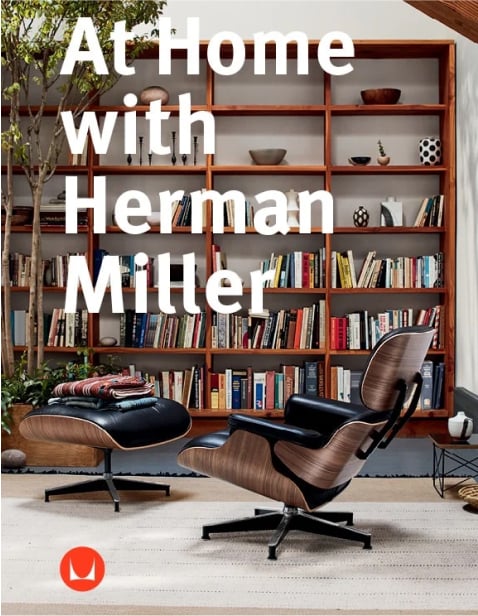 A black leather Eames Lounge Chair and Ottoman in front of a tall bookshelf holding small vases and colorful books.